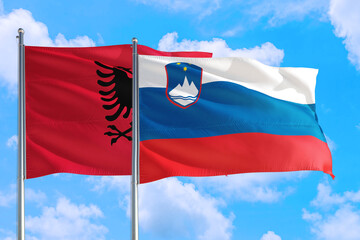 Slovenia and Albania national flag waving in the windy deep blue sky. Diplomacy and international relations concept.