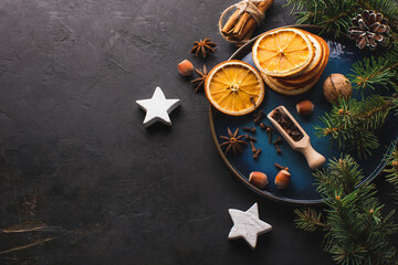 Top-down plan, festive food background. Christmas table decoration with branches of a Christmas tree and aromatic spices. Copy space.