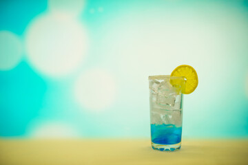 Blue cocktail with ice and lemons in a glass