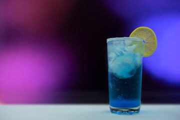 Blue cocktail with ice and lemons in a glass