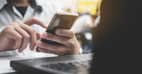 close up of business people use smartphone on desk  of computer notebook.