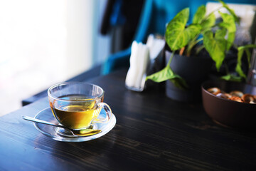 Hot steaming green tea in a cup on a rustic background
