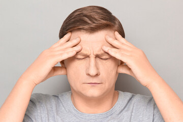 Portrait of thoughtful tired man touching temples with hands