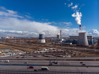 Industrial factory buildings and smoking chimney pipes. Combined heat and power station or thermal...