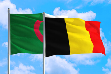 Belgium and Algeria national flag waving in the windy deep blue sky. Diplomacy and international relations concept.