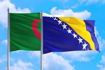 Bosnia Herzegovina and Algeria national flag waving in the windy deep blue sky. Diplomacy and international relations concept.