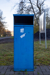 Fototapeta na wymiar blue trash can in a park