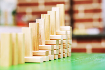 Stick wood block standing on stacked square wood blocks, abstract background in concept of winning, success, challenge, step to top position.