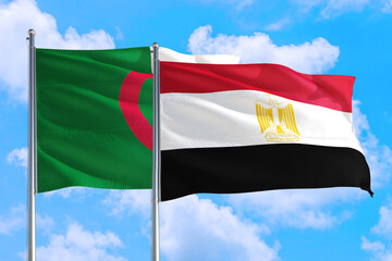 Fototapeta na wymiar Egypt and Algeria national flag waving in the windy deep blue sky. Diplomacy and international relations concept.