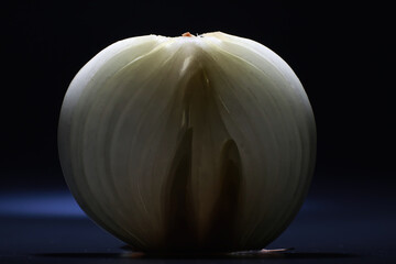 Fresh onion bulbs on black background. Bulb onion is rich in vitamins, useful spring. Onion peel on a dark background. Raw sliced onions.