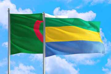 Gabon and Algeria national flag waving in the windy deep blue sky. Diplomacy and international...