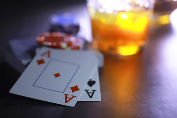 Gambling Card games for money. Texas Hold'em Poker. Cards in hand, playing chips, deck of cards of alcohol in a glass.