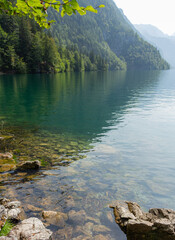 Berchtesgaden lake Königssee with trees in foreground and mountains in the background