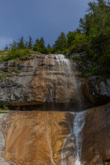 Berchtesgaden waterfall under the cliffs on a summer day at lake K&ouml;nigssee