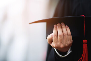 graduates ,close up student holding hats and tassel red in hand during commencement success of the university, Concept education congratulation. Graduation Ceremony.