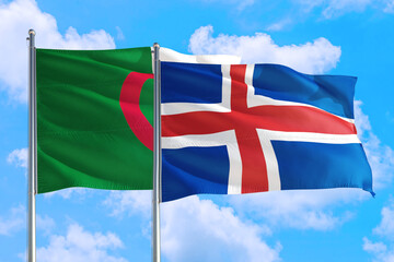 Iceland and Algeria national flag waving in the windy deep blue sky. Diplomacy and international...