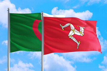 Isle Of Man and Algeria national flag waving in the windy deep blue sky. Diplomacy and...