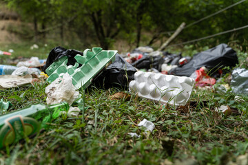 Pollution in nature - garbage thrown on the field covering grass - trash in the countryside on...