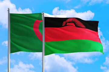 Malawi and Algeria national flag waving in the windy deep blue sky. Diplomacy and international relations concept.