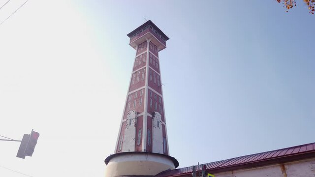 Cinematic slow motion video of Fire-Observation Tower in historical center of ancient touristic town Rybinsk in Yaroslavl oblast in Russian Federation. Beautiful summer sunny look of old building