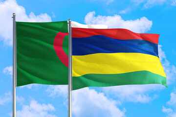 Mauritius and Algeria national flag waving in the windy deep blue sky. Diplomacy and international relations concept.