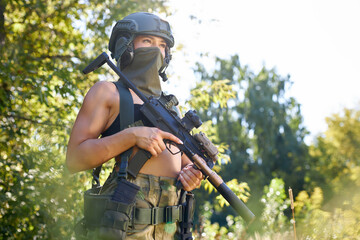 attractive brave military woman with a gun in forest, survival in wild forest, caucasian female in...