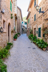 Fototapeta na wymiar beautiful street with stone buildings decorated with flowers in Valldemossa old town, Mallorca island, Spain