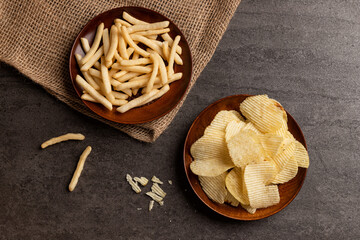 Top view of potato chips and french fries snack in dish.