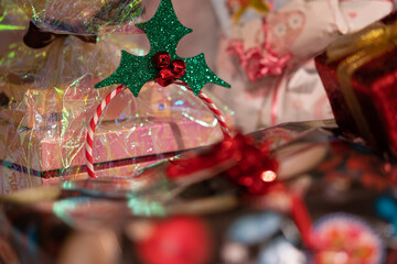 Handmade decorated christmas gifts with holly, red, pink and golden ribbon. Background for christmas theme.