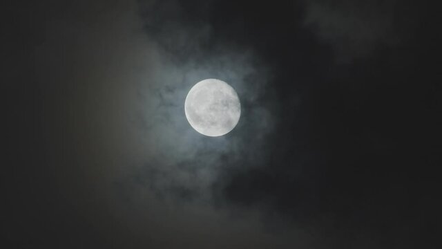 Full moon against cloudy night sky