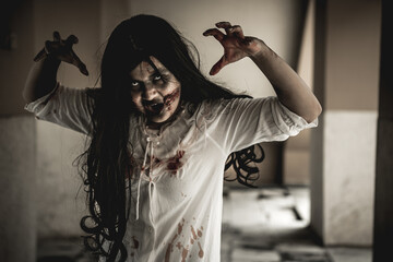 Woman in ghost or zombie on halloween festival at dark place, holding knife and wants to stab you....