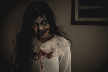 Woman in ghost or zombie on halloween festival at dark place, holding knife and wants to stab you....