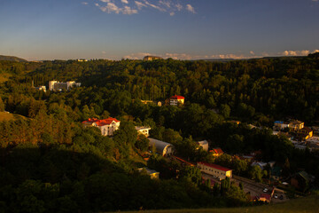 View from the mountain to the city park and houses with sunbeams