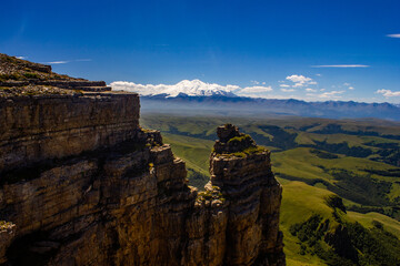 An excellent view from the plateau to the extinct volcano and the snowy peak of Mount Elbrus. Below is a green gorge