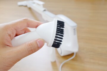 His hand and Her hand holding the equipment for the Vacuum cleaner/Woman use vacuum cleaner. Close up.
