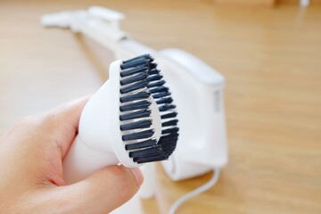 His hand and Her hand holding the equipment for the Vacuum cleaner/Woman use vacuum cleaner. Close up.