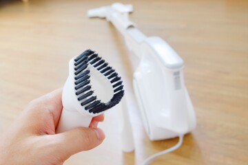 His hand and Her hand holding the equipment for the Vacuum cleaner/Woman use vacuum cleaner. Close up.