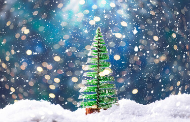 Little Christmas tree toys in snowdrift, winter New Year concept. Festive composition on blue background with lights and snowflakes