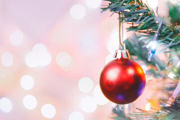 Christmas decoration. Red balls hanging on pine branches christmas tree garland and ornaments over abstract bokeh background with copy space