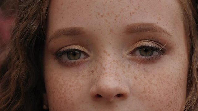 Close-up of a little girl's face with red hair and freckles. Portrait.