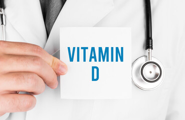Doctor holding a card with text VITAMIN D, medical concept