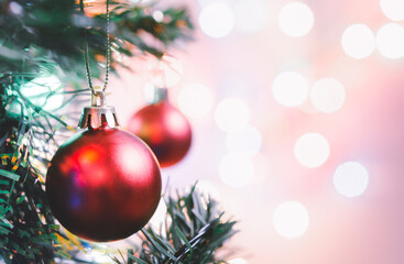 Christmas decoration. Red balls hanging on pine branches christmas tree garland and ornaments over abstract bokeh background with copy space