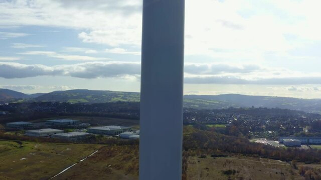 4K Aerial shot of large wind turbine up close climbing altitude from botom upwards showing sheer size of turbine