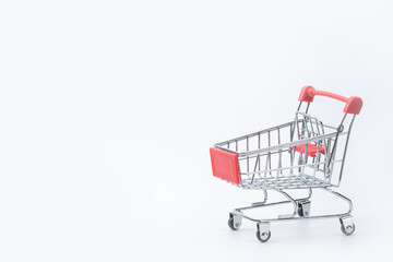 Shopping concept - Red shopping cart on white background with copy space.