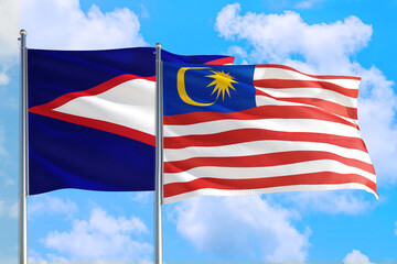 Malaysia and American Samoa national flag waving in the windy deep blue sky. Diplomacy and international relations concept.