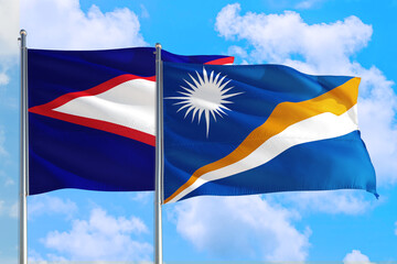 Marshall Islands and American Samoa national flag waving in the windy deep blue sky. Diplomacy and...