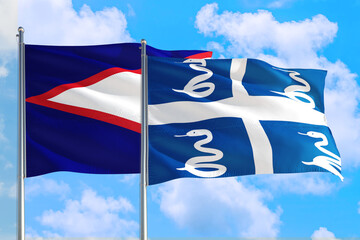 Martinique and American Samoa national flag waving in the windy deep blue sky. Diplomacy and...