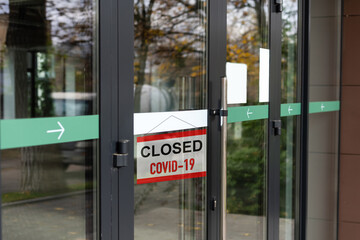 Naklejka premium Sorry we're closed sign. grunge image hanging on a dirty glass door