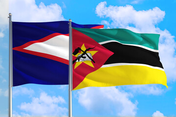 Mozambique and American Samoa national flag waving in the windy deep blue sky. Diplomacy and international relations concept.