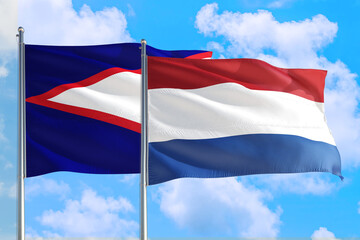 Netherlands and American Samoa national flag waving in the windy deep blue sky. Diplomacy and...